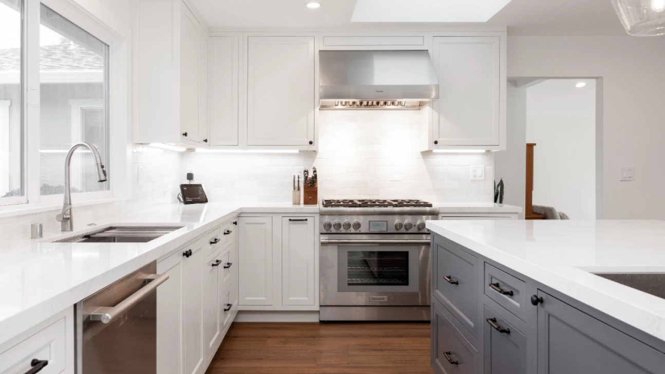 Modern San Francisco kitchen remodel with white shaker cabinets, gray island, quartz countertops, and stainless steel range