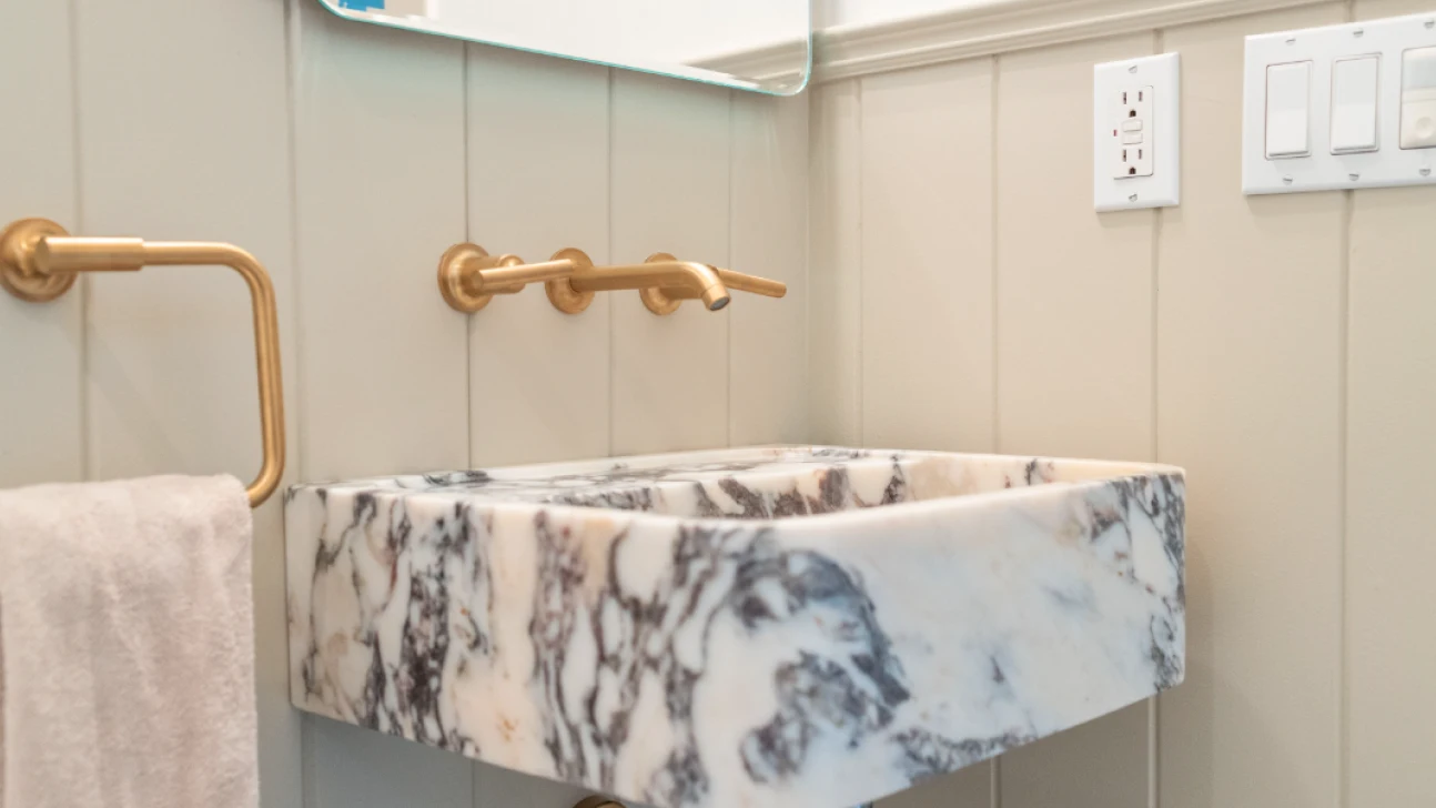 Contemporary Bay Area bathroom renovation featuring marble vessel sink, brushed brass wall-mounted faucet, and vertical paneling for added texture