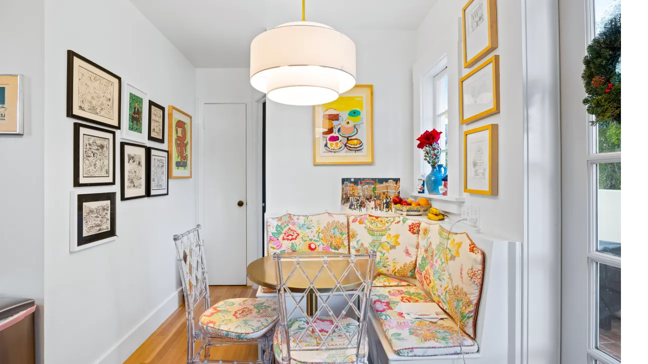 Bay Area breakfast nook with floral upholstered banquette, gallery wall art, and pendant lighting in bright remodel