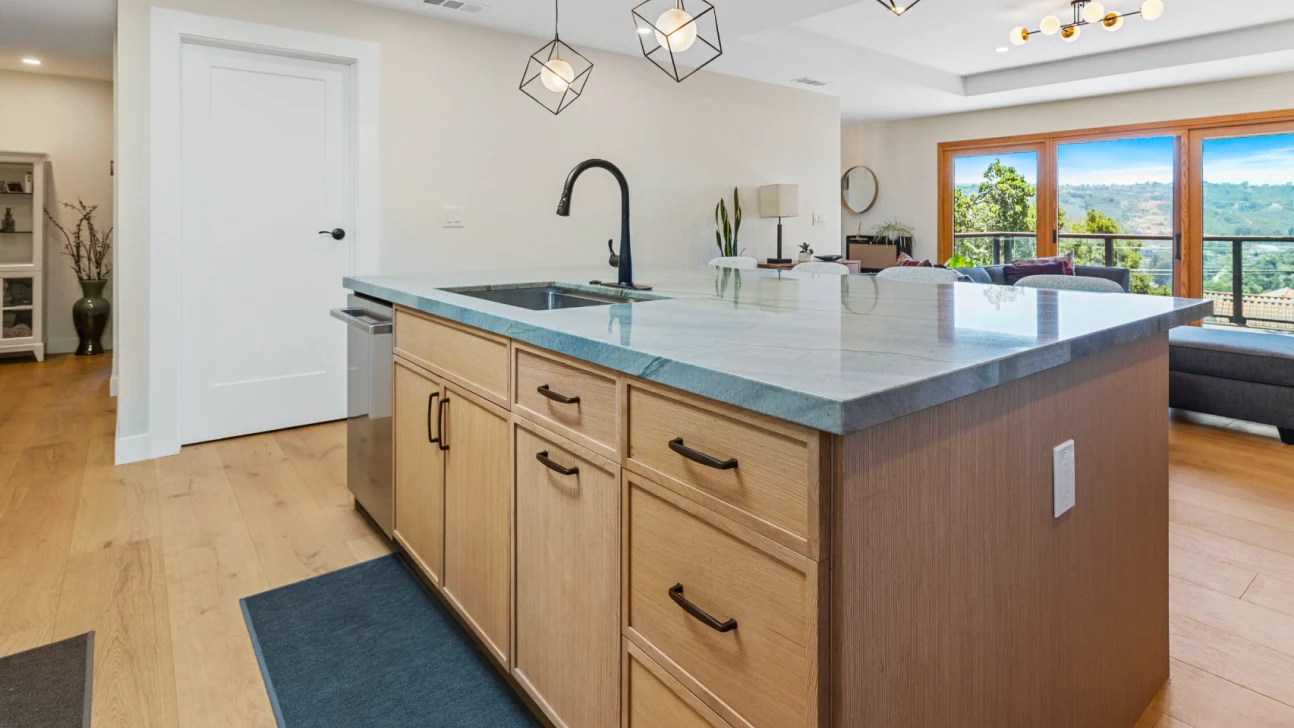Modern San Francisco kitchen remodel with waterfall island, mixed wood and white cabinetry, geometric pendant lighting, and open-concept layout