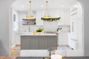kitchen with grey island and brass pendant lights framed by arched entry in contemporary San Francisco kitchen remodel
