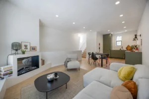 Renovated open-concept living room with fireplace, dining area, and kitchen completed by Mission Home Remodeling.