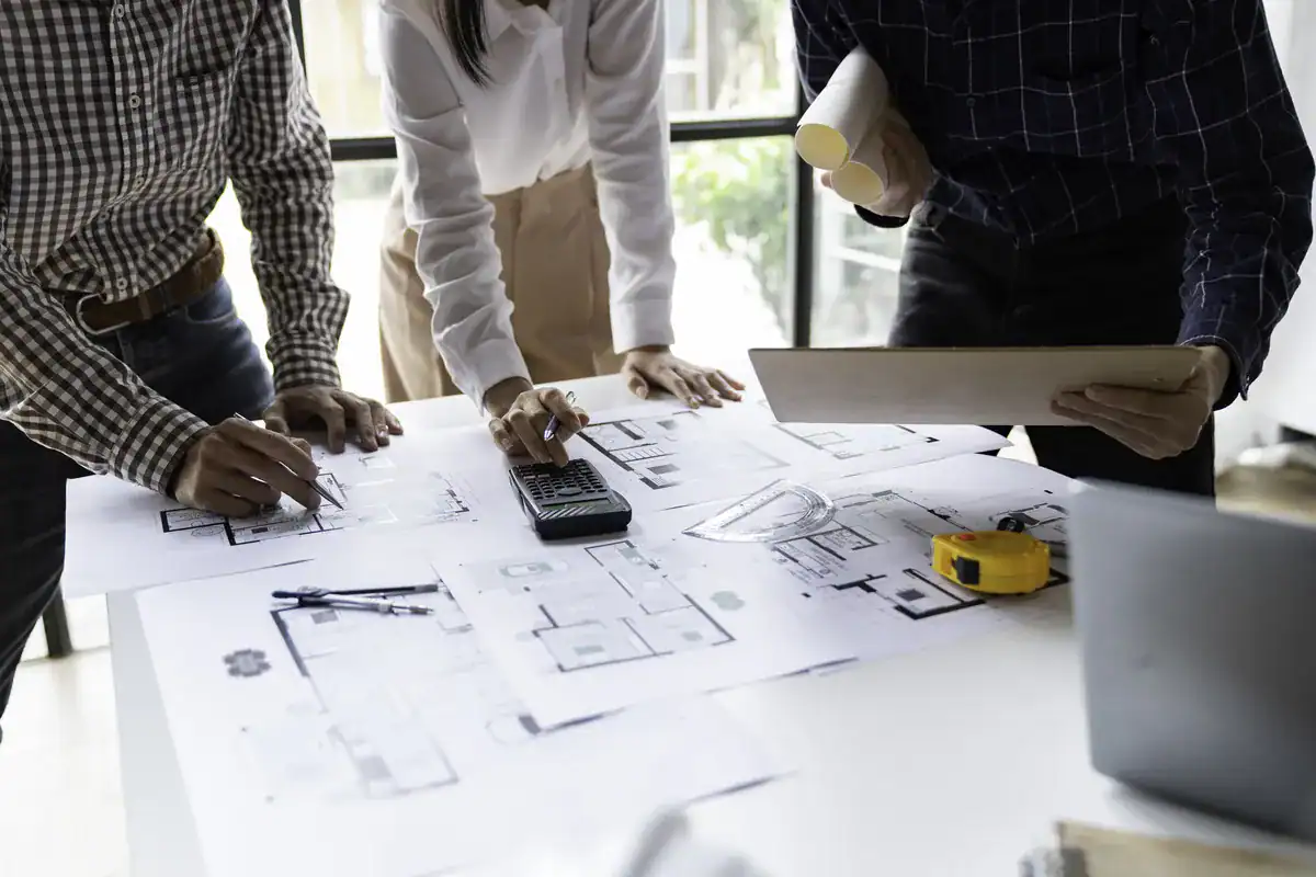 Construction team reviewing residential remodeling blueprints and project plans